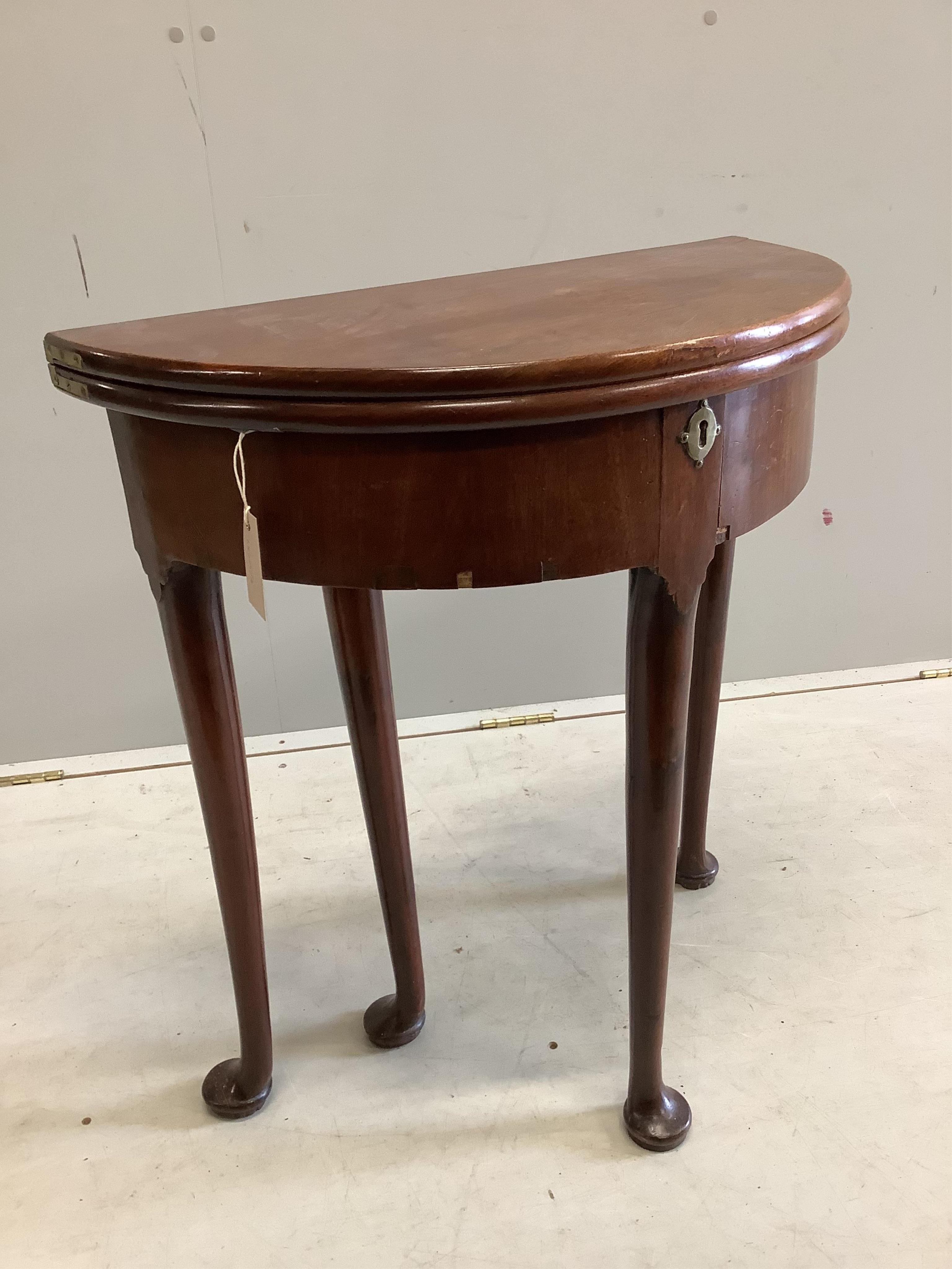 A small George II and later demi lune folding mahogany tea table, width 64cm, depth 32cm, height 70cm. Condition - fair